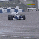 a blue and white race car is driving on a road