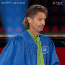 a man in a blue gown and green shirt has a name tag that says tim on it