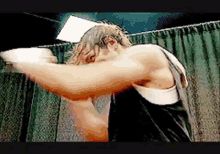 a man in a black tank top is boxing in a dark room