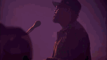 a man singing into a microphone in front of a screen that says ' a '