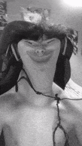 a black and white photo of a shirtless man wearing headphones and a fork around his neck