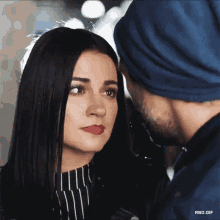 a close up of a woman looking at a man 's face with rbd.gif at the bottom
