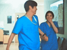 a man and a woman are holding hands in a hallway