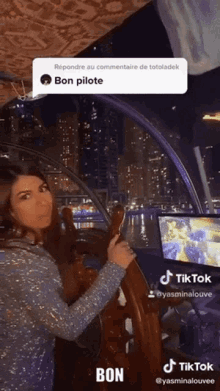 a woman is holding a steering wheel in front of a screen that says tiktok