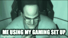 a man with glasses is sitting in a chair with the words me using my gaming set up below him