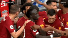 a group of soccer players are hugging each other and one of them has the number 1 on his shirt
