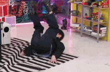 a man is doing a handstand on the floor in a room .