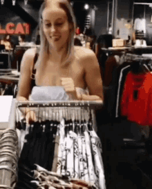 a naked woman is looking at clothes in a clothing store .