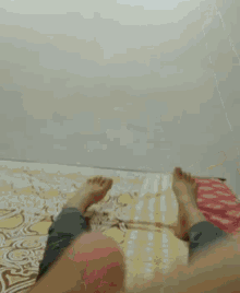 a person is laying on a bed with their feet up