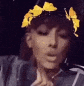 a woman wearing a hat with butterflies on it and a flower crown on her head .