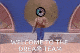 a man with a circle on his head is walking with the words welcome to the dream team behind him