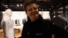 a man wearing a black dupreeh sweatshirt smiles