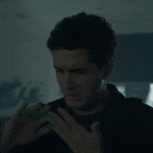 a man with a green ring on his finger is making a funny face