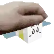 a hand is holding a white box with a face drawn on it .
