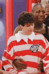 a man wearing a red and white striped shirt has a patch on his chest that says ' jaguar '