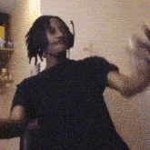 a man wearing headphones and a black shirt is dancing in a room