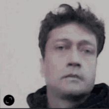 a close up of a man 's face with a hoodie on .