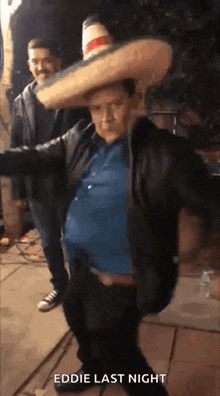 a man wearing a sombrero and a leather jacket is dancing with another man .