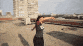 a woman dancing on a rooftop wearing a shirt that says ' chicago ' on it