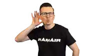 a man wearing a ramair shirt holds his hand to his ear while making a funny face