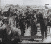 a black and white photo of a group of people walking