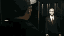a man is standing in front of a broken glass door in a dark room .