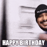 a man wearing a beanie and a nose ring is smiling and says `` happy birthday '' .