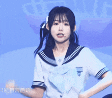 a girl in a sailor uniform stands in front of a blue background