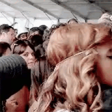 a group of people are standing next to each other in a crowded room .