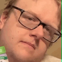 a man wearing glasses is making a funny face and looking at the camera .