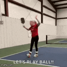 a girl is holding a tennis racquet on a tennis court and says let 's play ball !