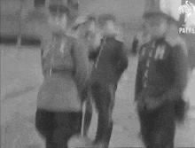 a black and white photo of a group of men in uniform standing next to each other .