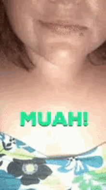 a close up of a woman 's face with the word muah written in green .