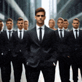 a man in a suit stands in front of a group of men in suits and ties