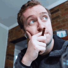 a man with a beard is holding a pencil in his hand