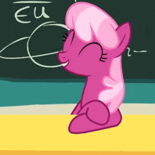 a pink pony sits at a desk in front of a blackboard with eu written on it