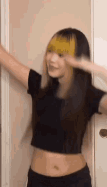 a woman with yellow hair is standing in front of a door .