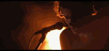 a person singing into a microphone with a fire in the background