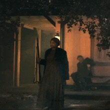 a man sitting on a porch holding a gun