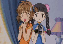 two anime girls are standing next to each other with one holding a video camera