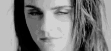 it is a black and white photo of a woman with her eyes closed .