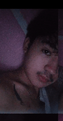 a shirtless man with a tattoo on his chest is looking at the camera