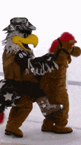 an eagle mascot is carrying a stuffed horse with a red mane