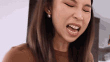 a close up of a woman 's face with her mouth open and her eyes closed .