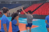 two women are standing on a volleyball court holding a sign that says ball in / out