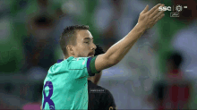 a soccer player wearing a green jersey with the number 8 on it