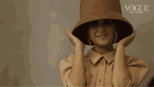 a woman wearing a hat with vogue written on it