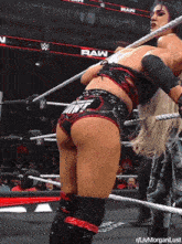 a woman in a wrestling ring with the word raw on the jumbo tron