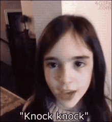 a little girl is making a funny face and saying knock knock .