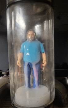 a plastic figurine of a man in a blue shirt and jeans